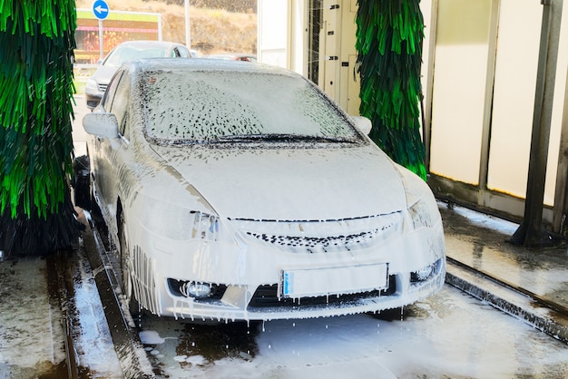 Laver une voiture grise avec du savon à la gare