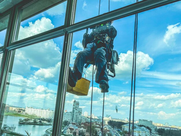 Laveur De Vitres Travaillant à L'extérieur Du Bâtiment