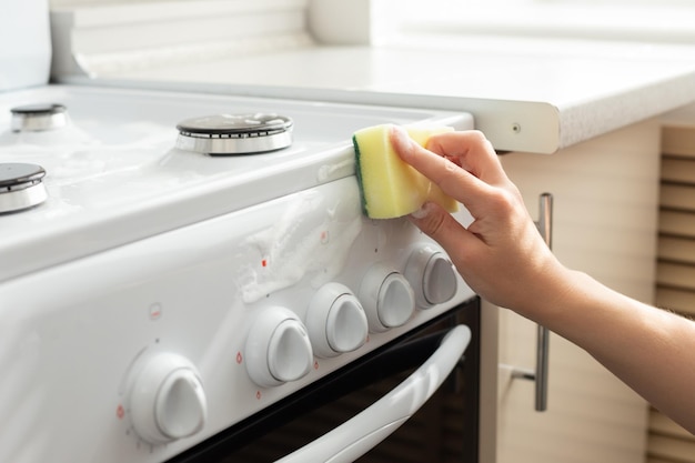 Lavez le poêle dans la cuisine avec une éponge pour le nettoyer de la graisse