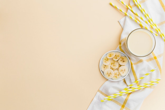 Photo lay plat de smoothie et de tranches de banane