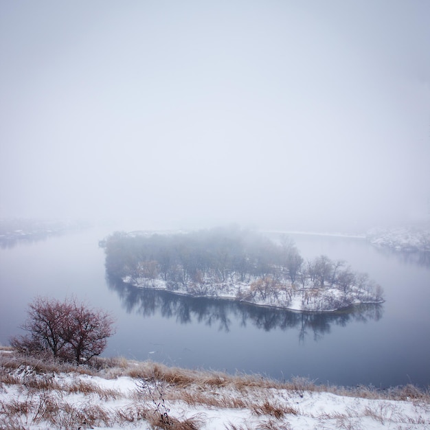 Île dans le brouillard sur la rivière en hiverx9xA