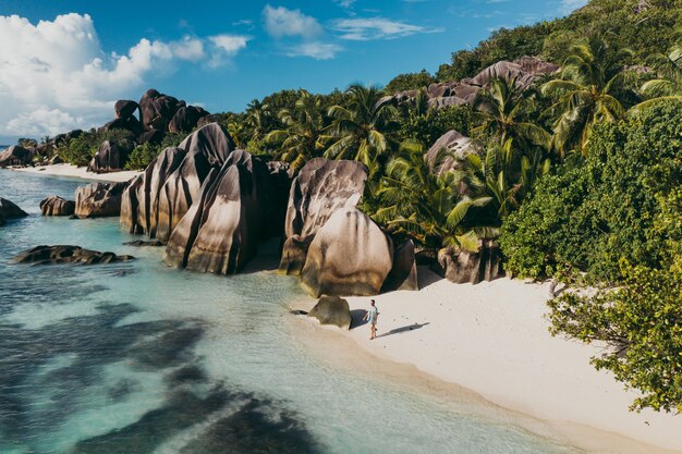 Île "La digue" aux Seychelles. Plage d'argent avec pierre granitique et jungle. Homme profitant de vacances et se détendre sur la plage. Vue aérienne