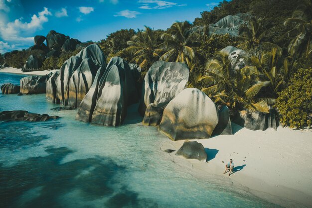 Île "La digue" aux Seychelles. Plage d'argent avec pierre granitique et jungle. Homme profitant de vacances et se détendre sur la plage. Vue aérienne