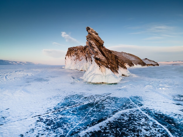 Île d'Ogoy sur le lac Baïkal d'hiver avec de la glace bleue fissurée transparente. Baïkal, Sibérie, Russie. Beau paysage d'hiver au coucher du soleil.