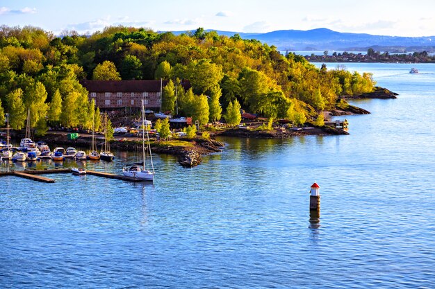 Île avec port et voiliers, vue depuis l'eau