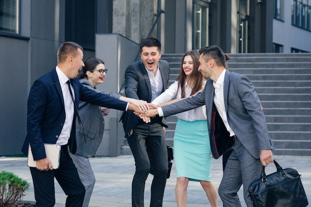 Un leader heureux motive divers employés Une équipe commerciale donne cinq ensemble, un groupe d'employés de bureau et un entraîneur engagés dans la consolidation d'équipe célèbrent le succès Bons résultats Récompense dans le concept de travail d'équipe.