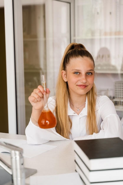 Leçon de chimie à l'école Une fille avec une fiole étudie en classe de chimie Une écolière tenant une fiole avec un produit chimique dans le laboratoire