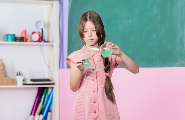 Leçon fascinante Leçon de sciences Laboratoire scolaire Expérience scientifique Petite fille avec tube chimique Éducation à la biologie Tube d'essai de cours de chimie pour filles Réaction chimique Liquide chimique