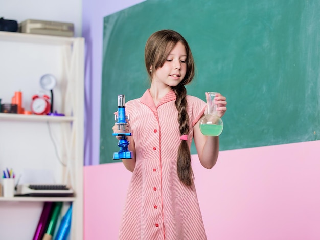 Leçon de sciences Laboratoire scolaire Expérience scientifique Tube d'essai de classe de chimie pour filles Petite fille avec tube chimique Enseignement de la biologie Réaction chimique Liquide chimique Leçon fascinante