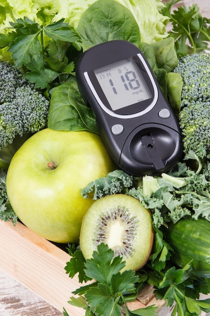 Lecteur de glycémie et fruits verts frais avec des légumes comme aliments sains contenant des vitamines Diabète et désintoxication du corps