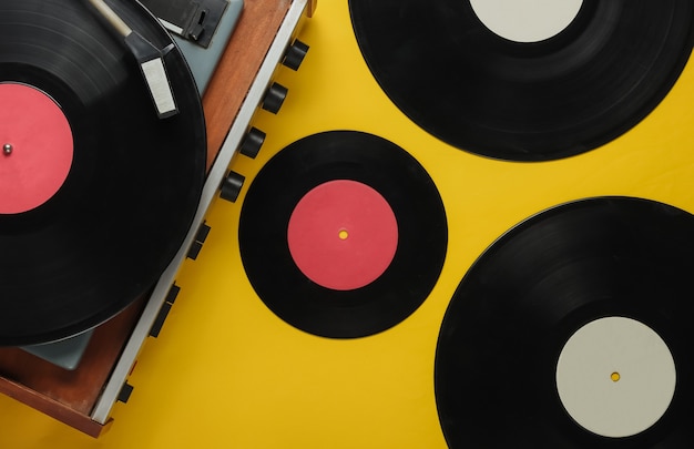 Lecteur de vinyle à l'ancienne avec des disques sur fond jaune