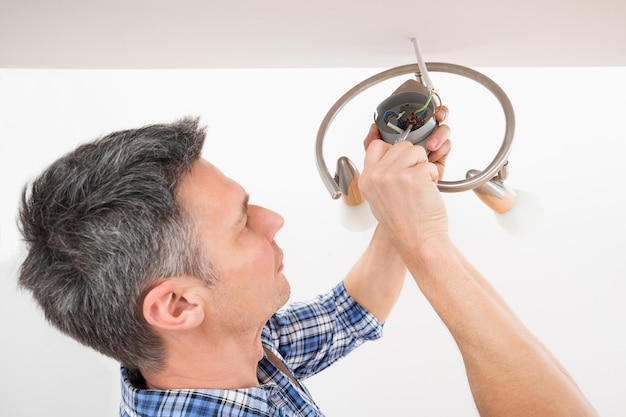 Électricien fixant la lumière au plafond