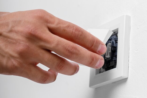 Électricien installant un interrupteur d'éclairage sur le mur. fermer