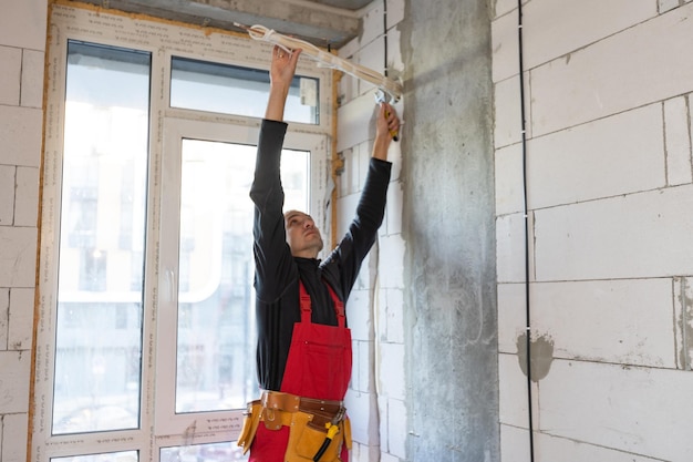 Électricien mesurant la tension du climatiseur sur le chantier.