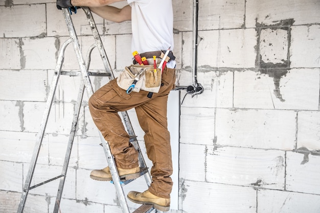 Électricien avec des outils, travaillant sur un chantier de construction