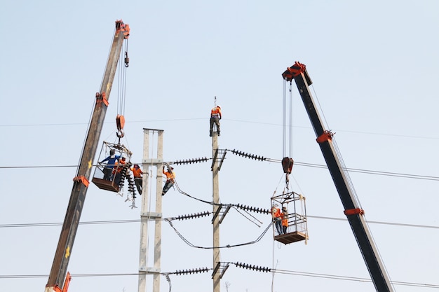 Électricien travaillant en hauteur en connectant un fil haute tension