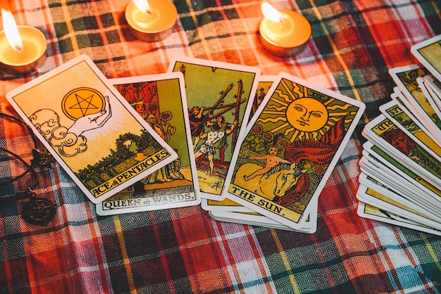 Lecture de tarot avec fond de carte de tarot et lumière de bougie sur la table pour l'astrologie, la magie occulte, les horoscopes spirituels et la lecture de la palme.