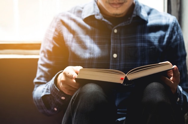 Lectures du dimanche, Bible. Jeune homme assis lisant la Bible dans l'espace.