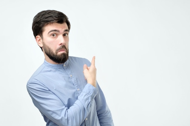 Élégant beau jeune homme hispanique pointant de côté