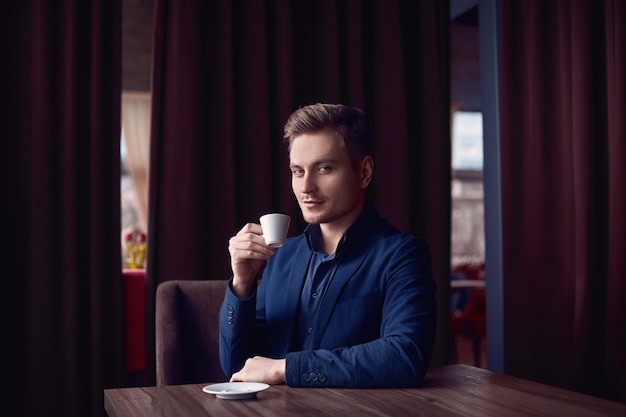 Élégant bel homme avec une tasse de café