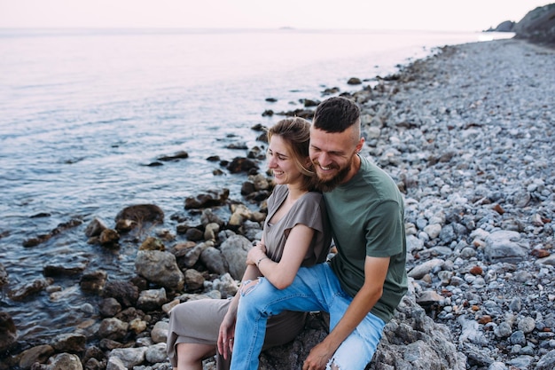 Élégant couple charmant marchant et étreignant au bord de la mer en profitant du temps ensemble