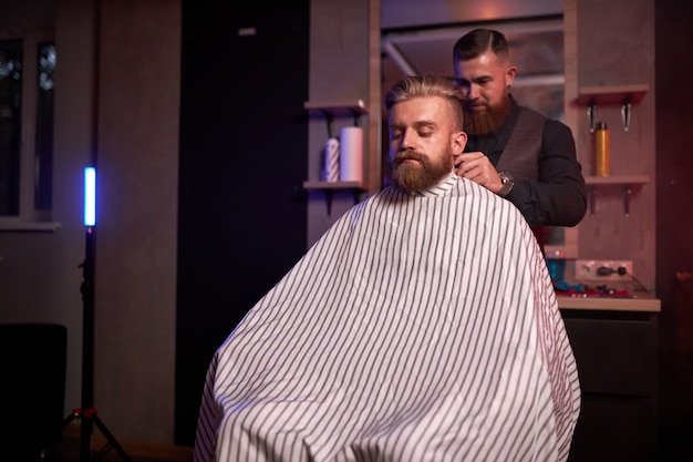 Élégant homme d'affaires barbu se toilettant chez le coiffeur