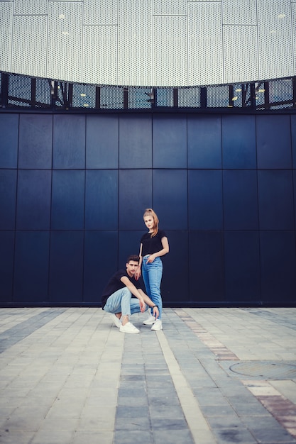 Élégant jeune couple près du mur bleu