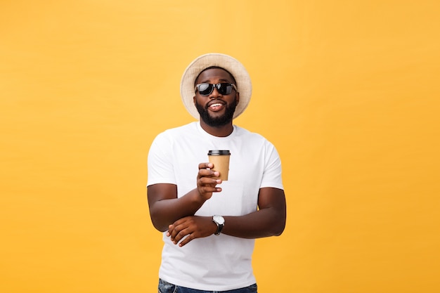 Élégant jeune homme afro-américain tenant une tasse de café à emporter isolé