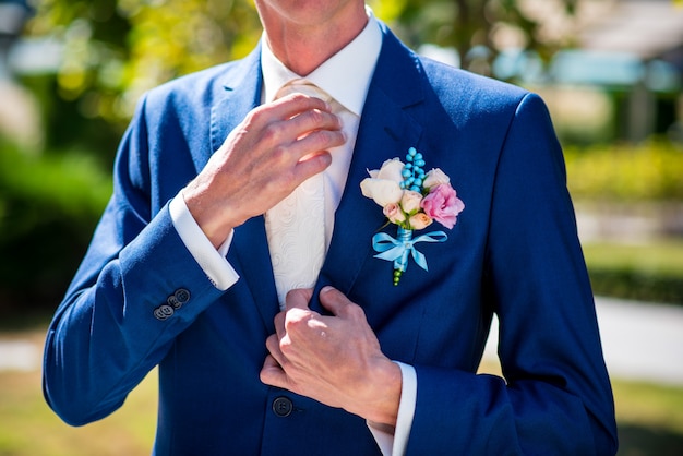 Élégant jeune homme boutonnant les boutons de manchette sur les manches. Style.