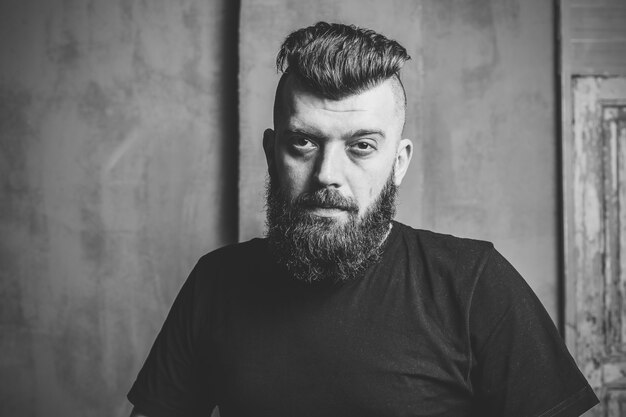 Élégant mâle hipster barbu. Portrait d'un homme brune avec une barbe. Noir et blanc