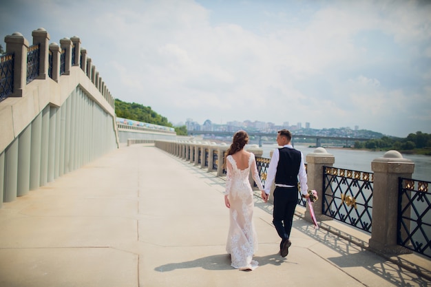 Élégant mariée et le marié posant sur le fond de la rivière.