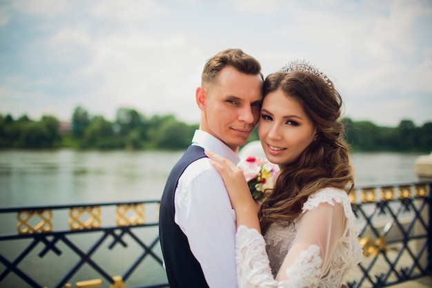 Élégant mariée et le marié posant sur le fond de la rivière.