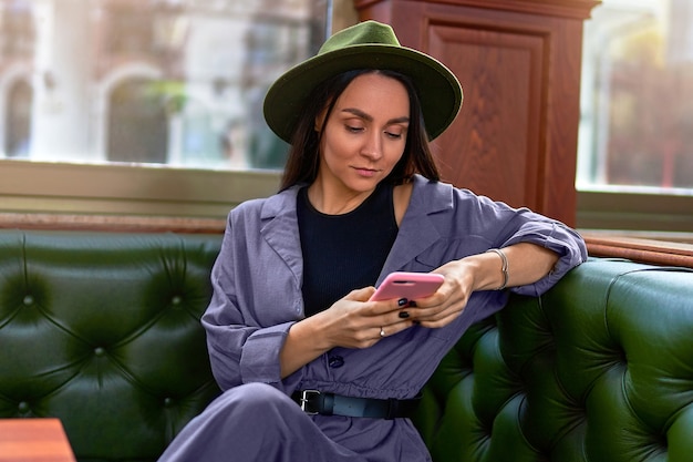 Élégant à la mode élégant voyageur de femme hipster attrayant mignon à l'aide d'un téléphone