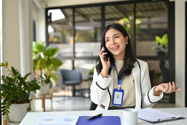 Élégante femme d'affaires asiatique parlant au téléphone avec un partenaire commercial