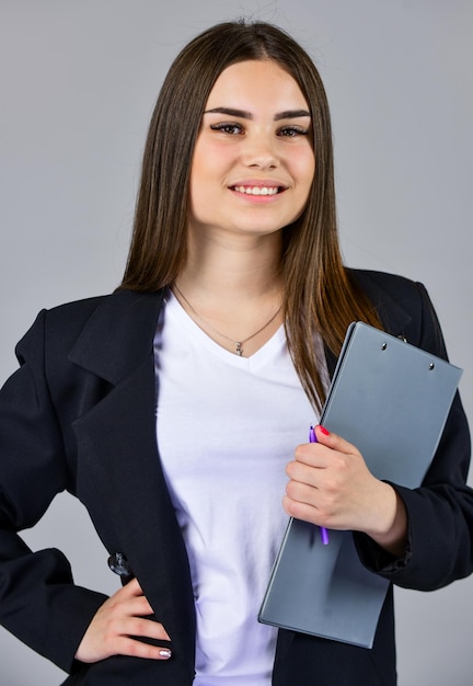 Élégante femme souriante en veste à la mode employé de bureau style de mode décontracté formel femme élégante tenir dossier de bureau fille suivre le code vestimentaire femme d'affaires confiante avec des documents