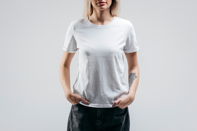 Élégante fille blonde portant un t-shirt blanc posant