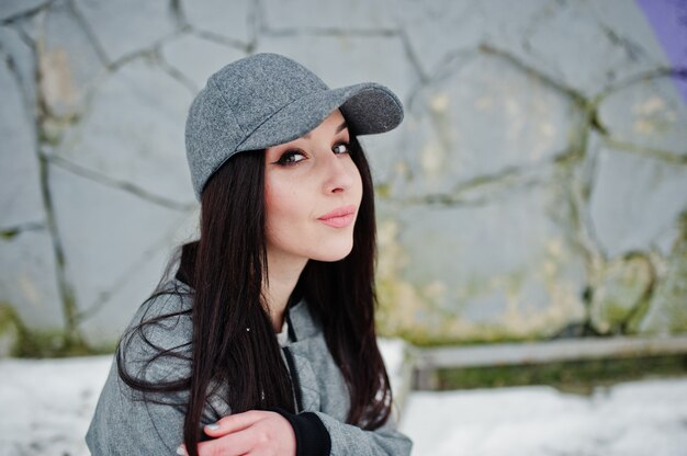 Élégante fille brune à casquette grise