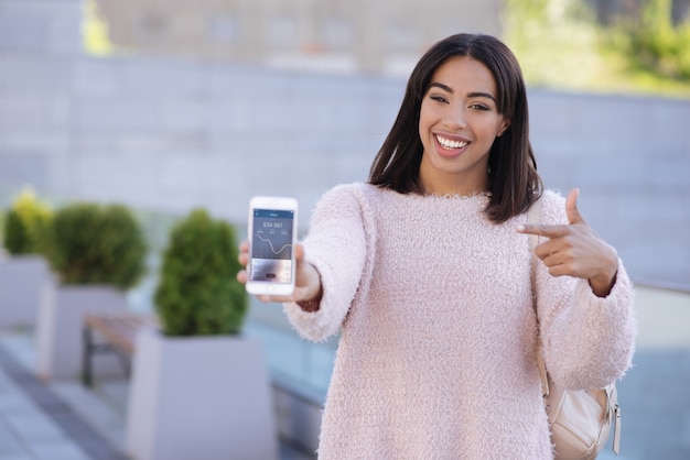 Élégante fille cool à la mode donnant à son ami un conseil et montrant à quoi ressemble l'application