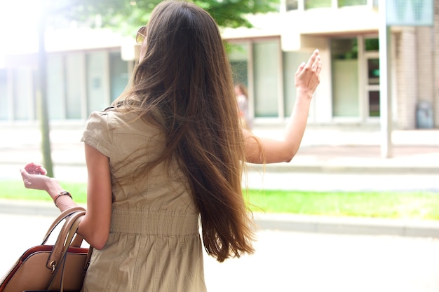 Élégante jeune femme agitant pour un taxi