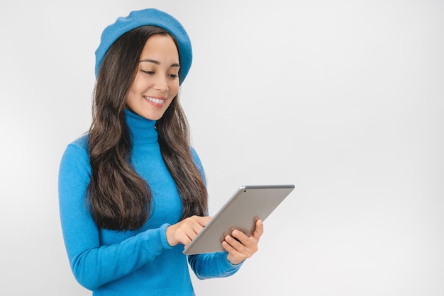 Élégante jeune femme à l'aide d'un ordinateur tablette isolé sur fond blanc