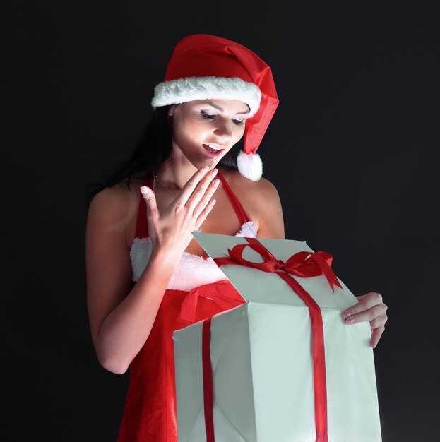 Élégante jeune femme en costume de père Noël avec cadeau de Noël. isolé sur un fond noir.