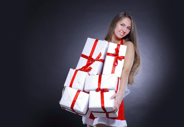 Élégante jeune femme en costume de père Noël avec cadeau de Noël. isolé sur un fond noir.