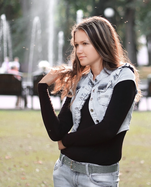 Élégante jeune femme sur fond de parc de la ville.