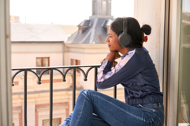 Élégante jeune femme indienne appréciant la musique sur les écouteurs