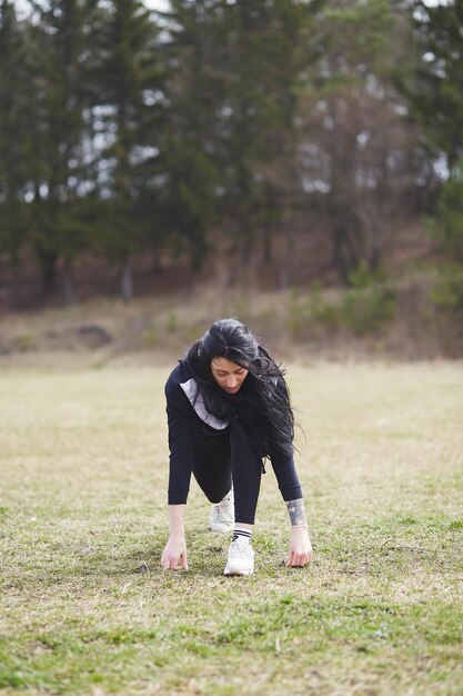 Élégante jeune femme mince en costume d'entraînement fait de l'exercice à l'extérieur Mode de vie sain et actif