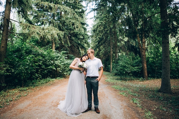 Élégante mariée et le marié posant ensemble à l'extérieur un jour de mariage