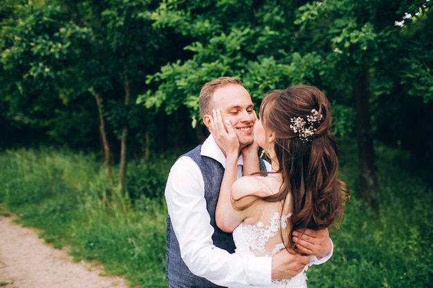 Élégante mariée et le marié posant ensemble à l'extérieur un jour de mariage