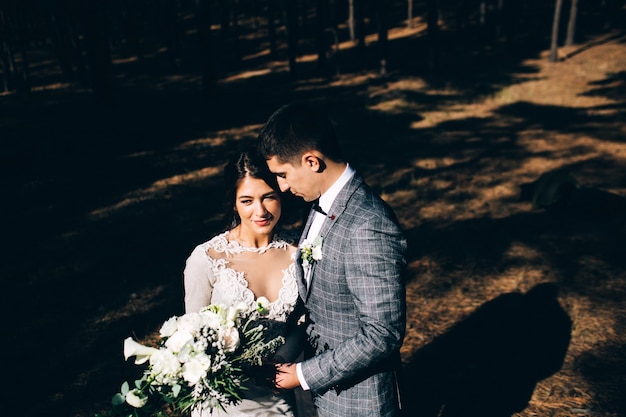 Élégante mariée et le marié posant ensemble à l'extérieur un jour de mariage