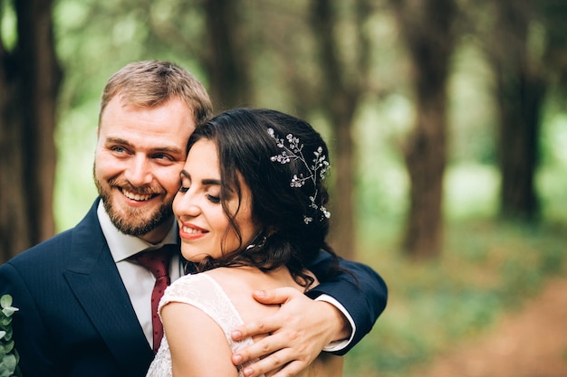 Élégante mariée et le marié posant ensemble à l'extérieur un jour de mariage