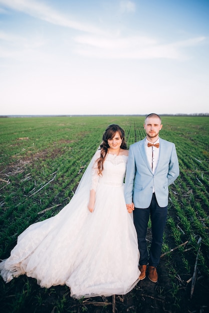 Élégante mariée et le marié posant ensemble à l'extérieur un jour de mariage